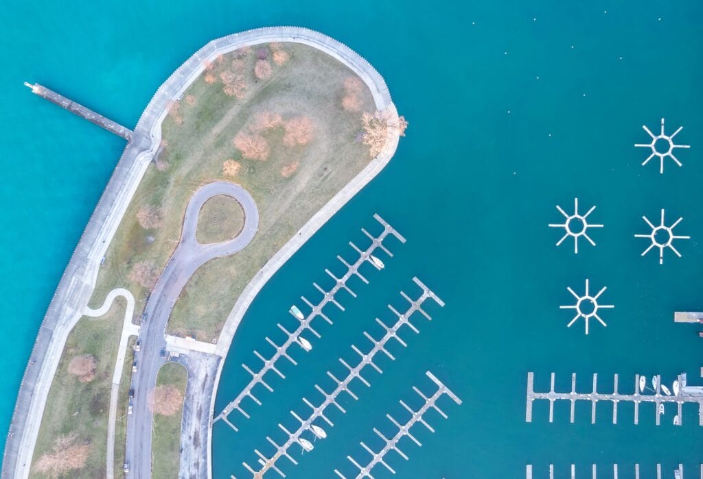 Aerial top view of green parks and harbors on a peninsula of Montrose, Chicago